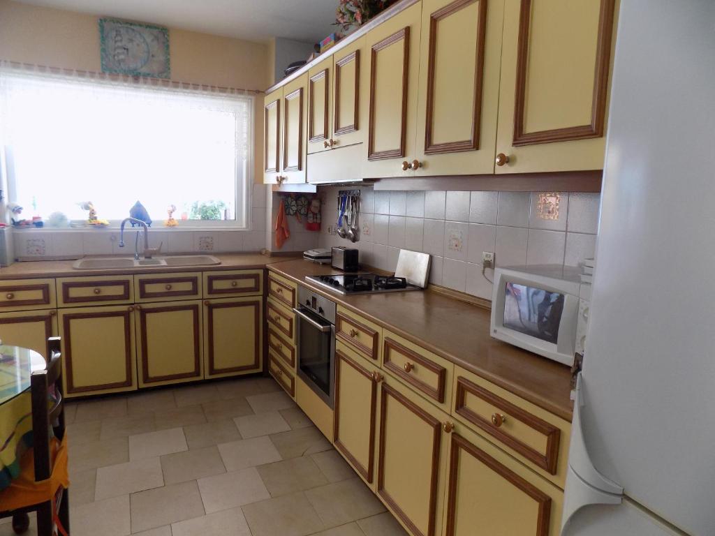 La cuisine est équipée de placards jaunes, d'un évier et d'un four micro-ondes. dans l'établissement Almyra View House, à Skopelos