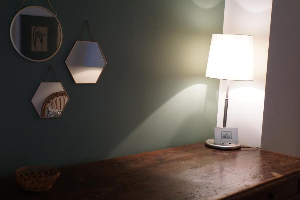 - une lampe au-dessus d'une table en bois dans une chambre dans l'établissement La Rotonda 2 Camere con terrazza in centro, à Pavia
