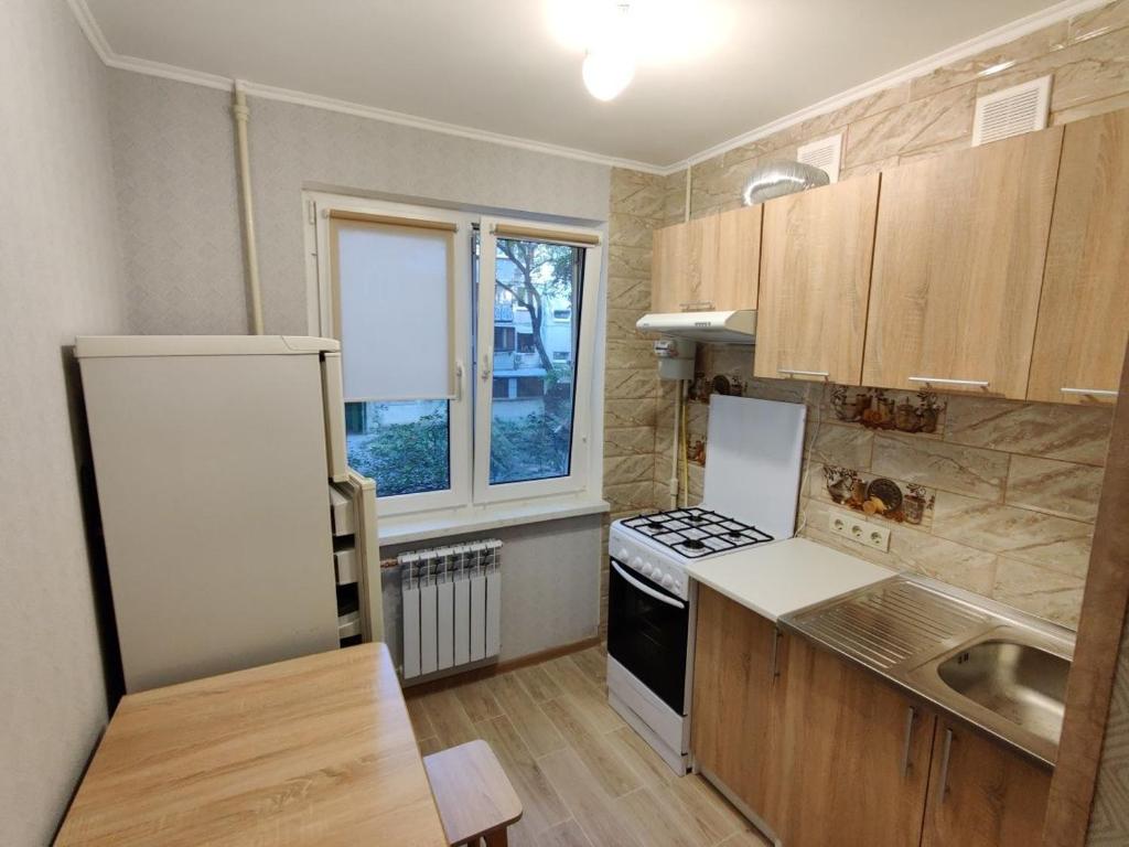 a small kitchen with a stove and a window at Filatov apartment in Odesa