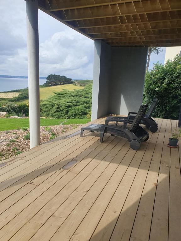 a deck with two lounge chairs on a porch at Reflets de la Mer... in Plomodiern