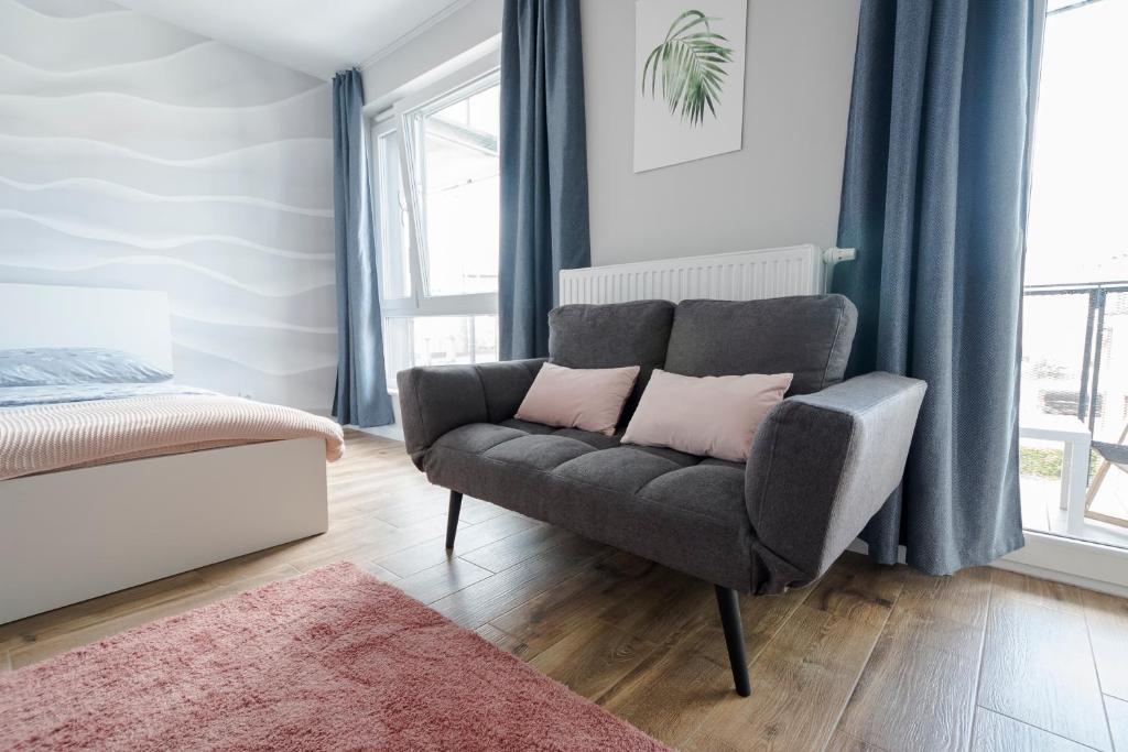 a living room with a couch and a bed at Apartament Alfa with free parking in Poznań