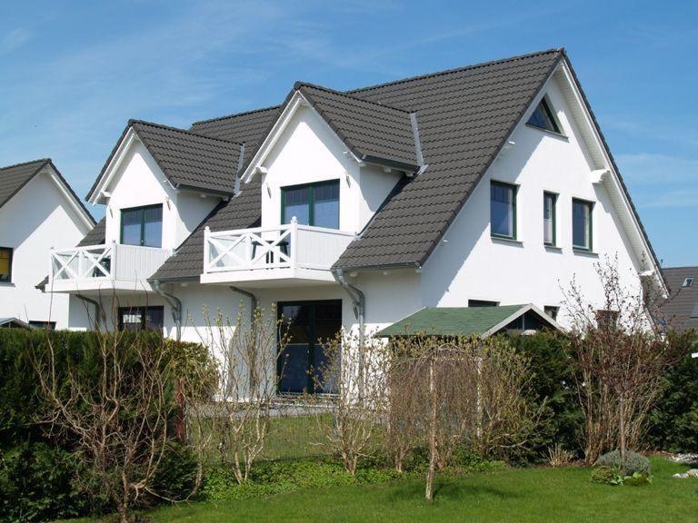 ein großes weißes Haus mit schwarzem Dach in der Unterkunft Ferienhaus Binz in Binz