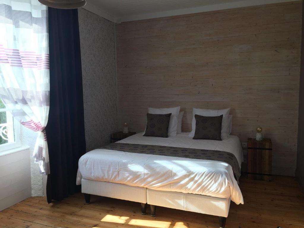 a bedroom with a bed and a window at Tilleuls et Bambous in Saint-Sauveur-dʼAunis