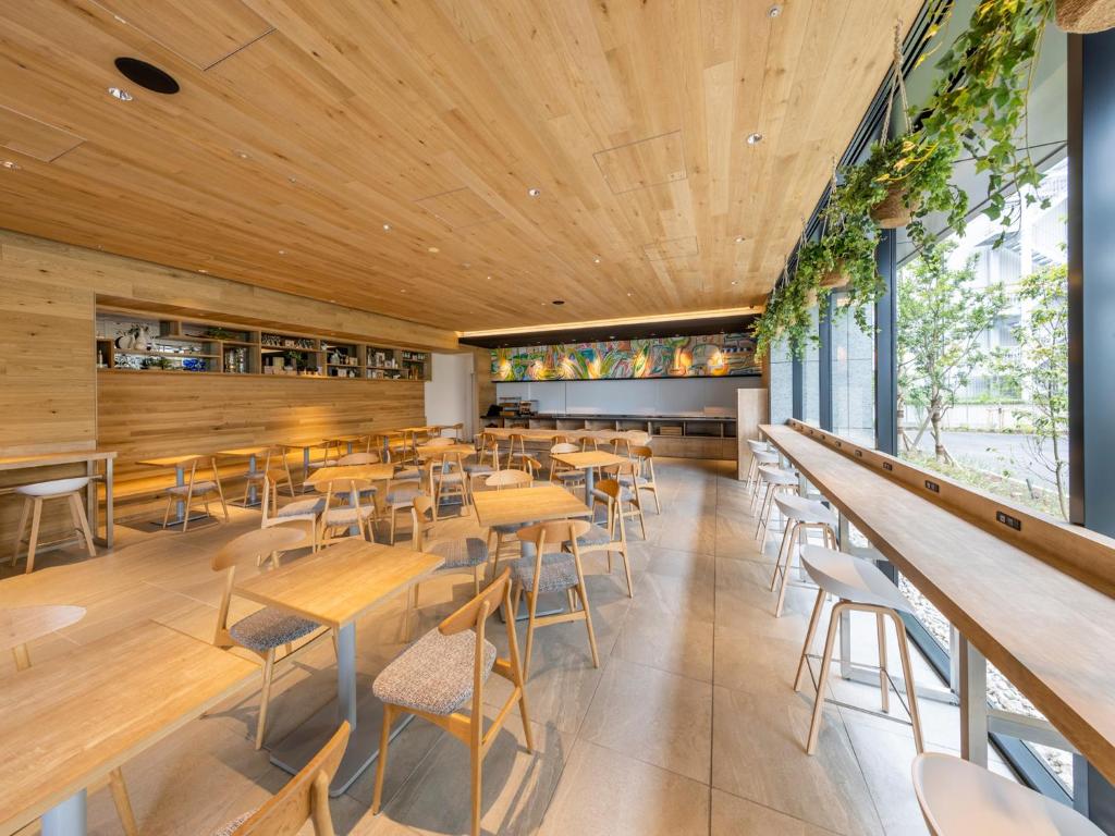 東京にあるファーイーストビレッジホテル東京有明の木製の天井、テーブルと椅子のあるレストラン