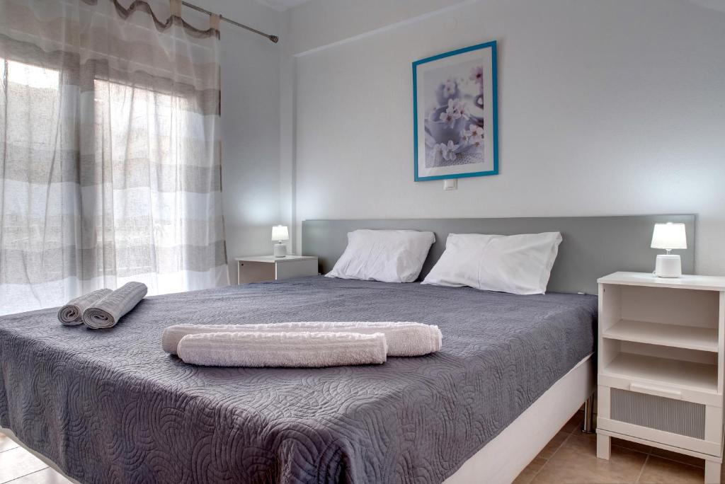 カリヴィア・ポリギロウにあるAchilleas Apartmentsのベッドルーム1室(ベッド1台、タオル2枚付)