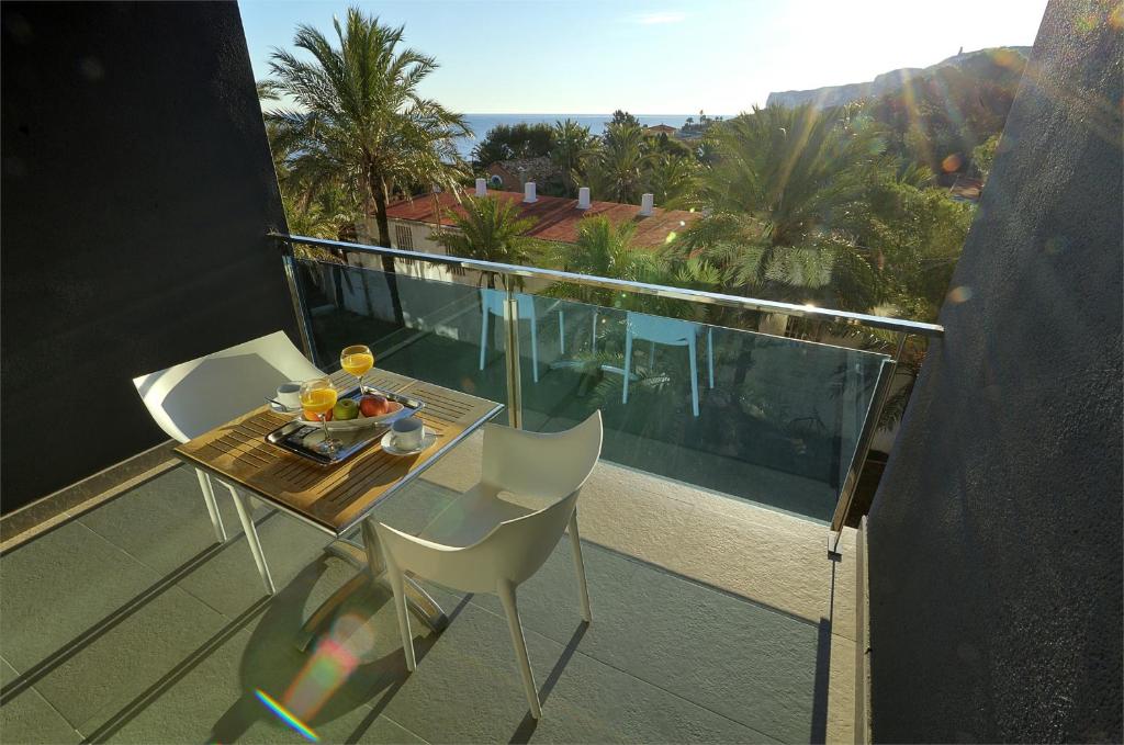 un tavolo e sedie su un balcone con vista sull'oceano di Apartamentos Bravosol VyB a Denia