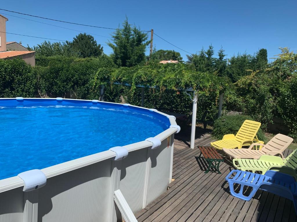 a deck with chairs and a swimming pool at les Sences in Bédarrides