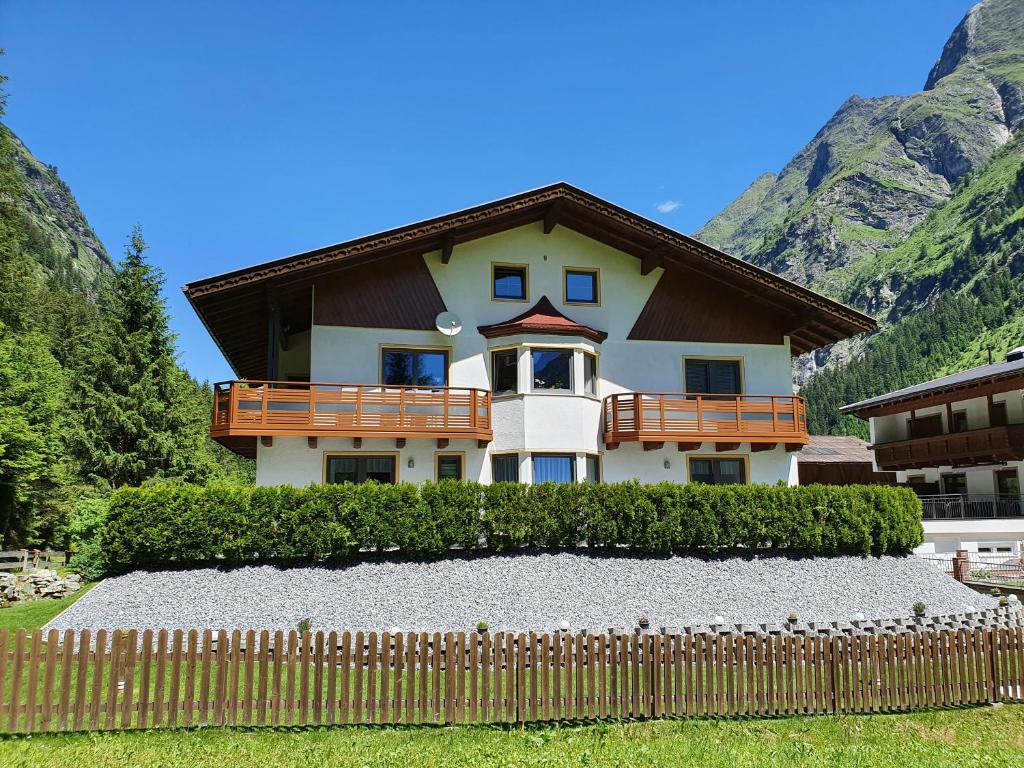 ein Haus mit einem Zaun davor in der Unterkunft Haus Bergheimat in Sankt Leonhard im Pitztal