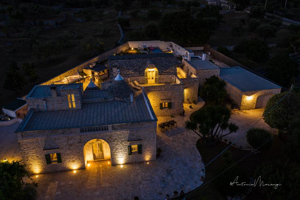 una vista aérea de una casa por la noche con luces en Villa Donatella, en Cisternino