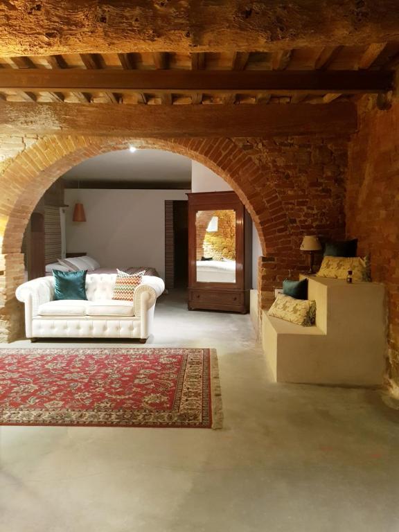 un soggiorno con divano bianco e tavolo di L' Atelier Tuscany a Peccioli