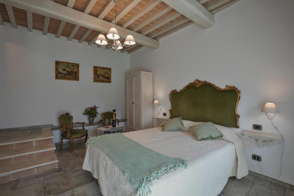 Un dormitorio con una cama grande con cabecero verde. en Agriturismo Alchimista, en Casole dʼElsa