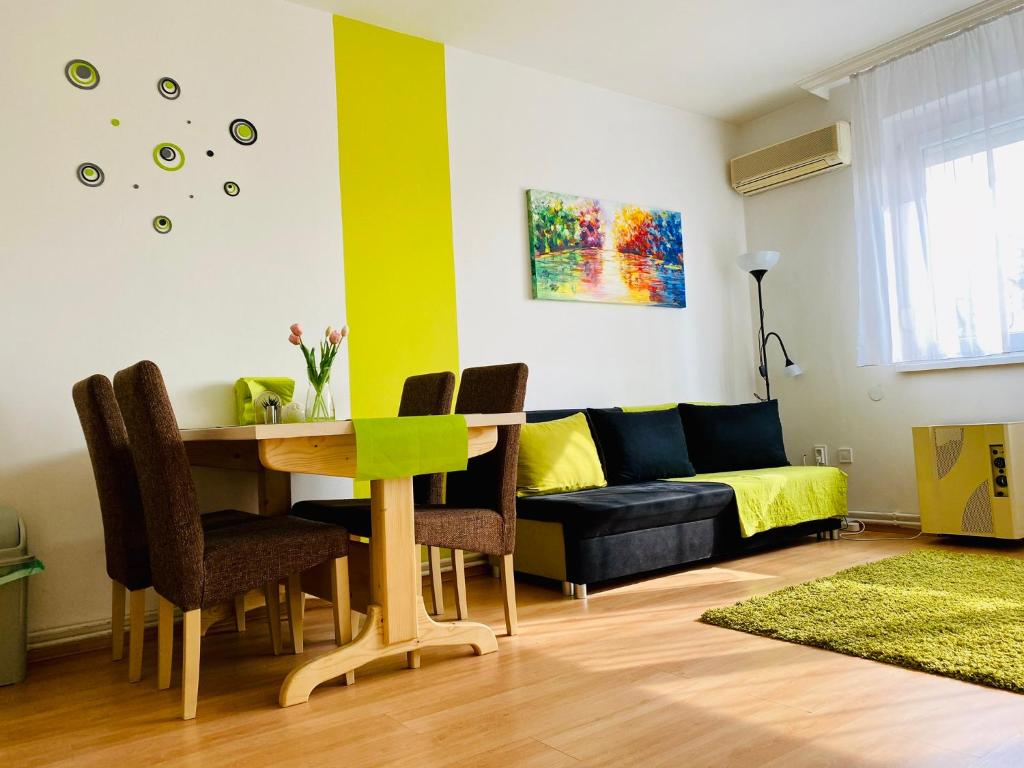 a living room with a table and a couch at Kálvária Apartman Szeged in Szeged