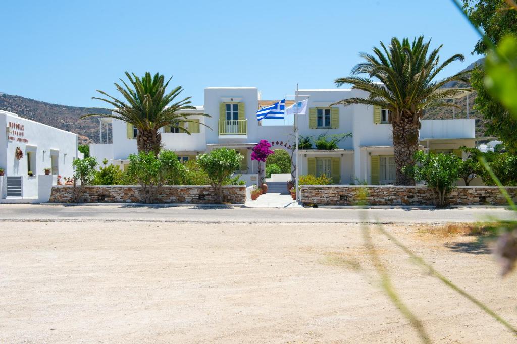 una casa bianca con palme di fronte di Morpheas Pension Rooms & Apartments a Kamárai