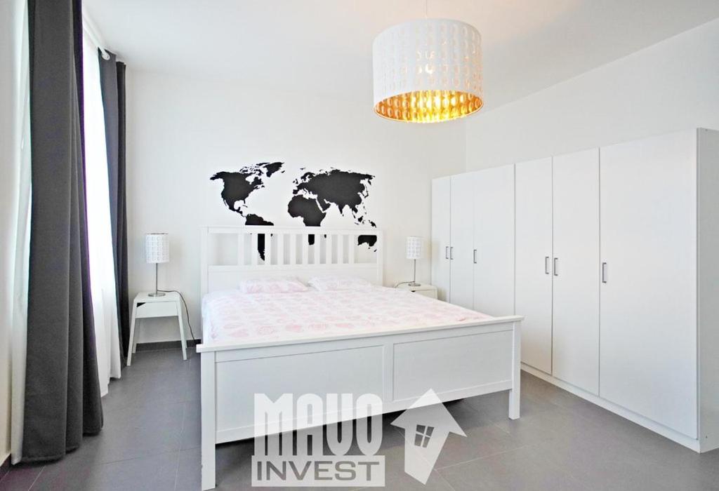 プラハにあるThe modern apartmentの白いベッドルーム1室(壁に地図が貼られた白いベッド1台付)