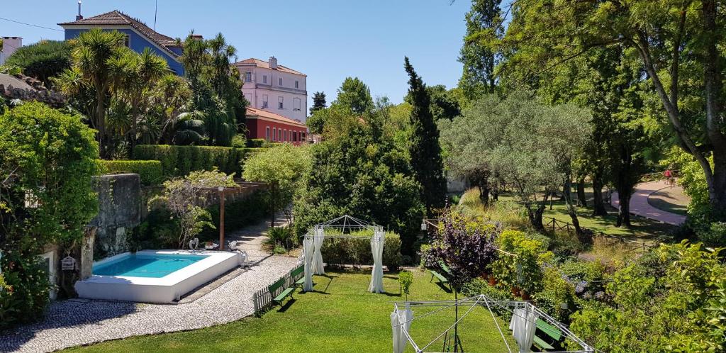 a garden with a swimming pool and a house at Vila Libania in Queluz