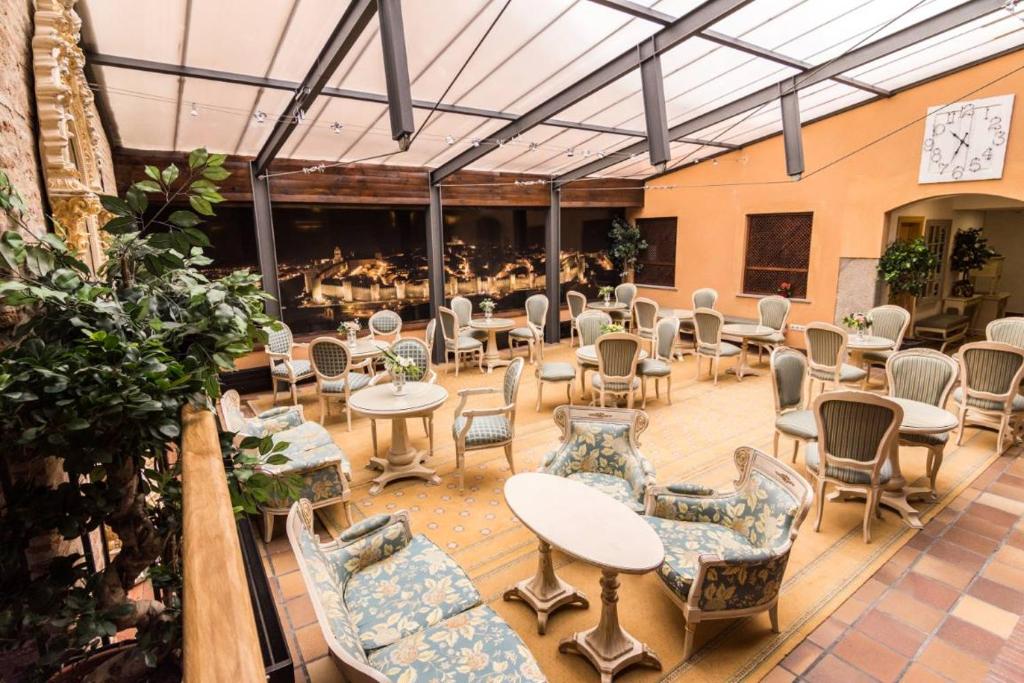 a patio with tables and chairs in a building at Antika Snoga in Avila