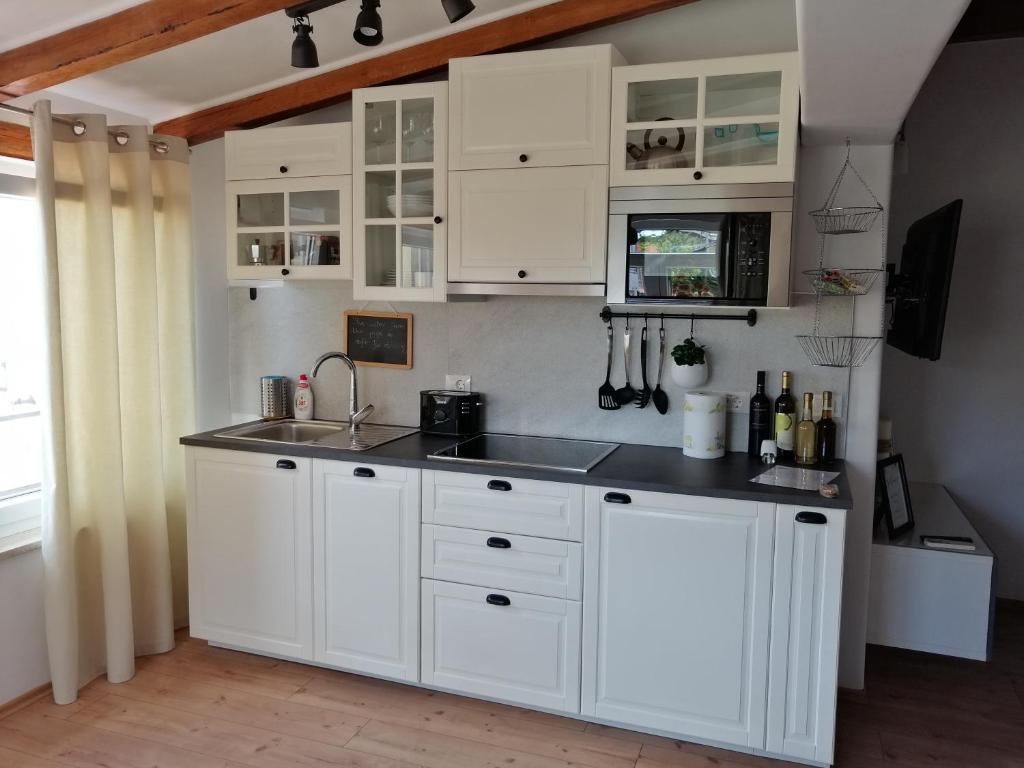 kuchnia z białymi szafkami i zlewem w obiekcie Danijela Rovinj sea view and free parking w Rovinj