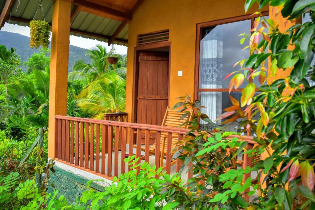 una veranda di una casa con porta in legno di Rainforest Nature House a Deniyaya