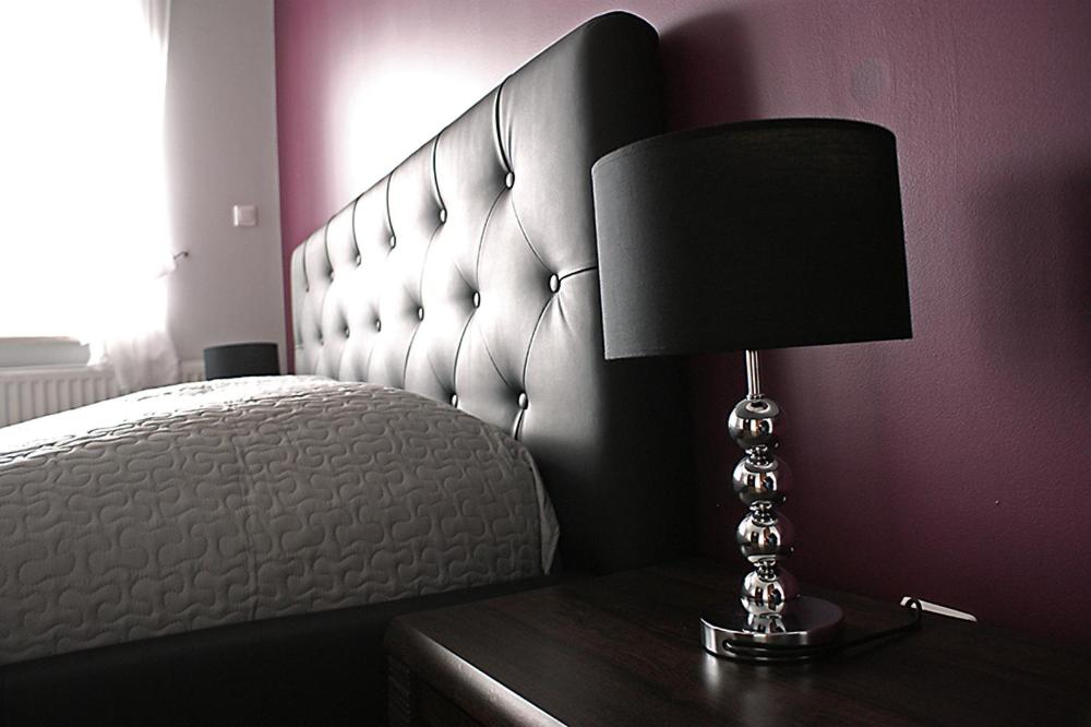- une chambre avec un lit et une lampe sur une table dans l'établissement Willa Dominik, à Jastarnia