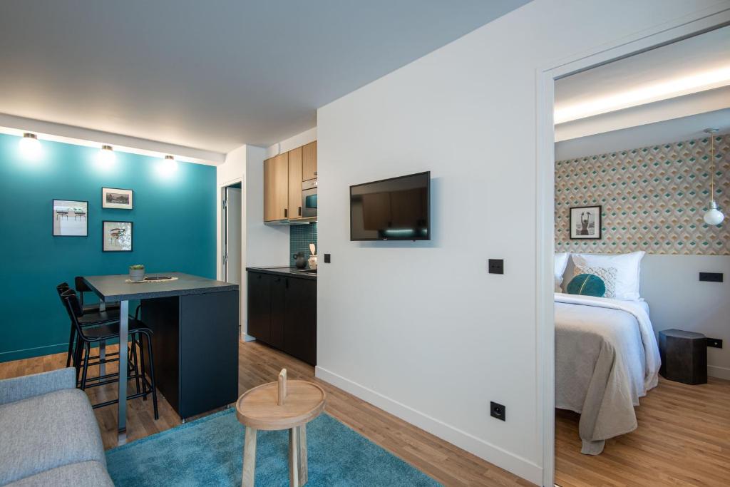 um quarto com uma cama, uma secretária e uma cozinha em NEW - Superbe 1 Bdr Appt - Design 60'S - Paris 15e em Paris