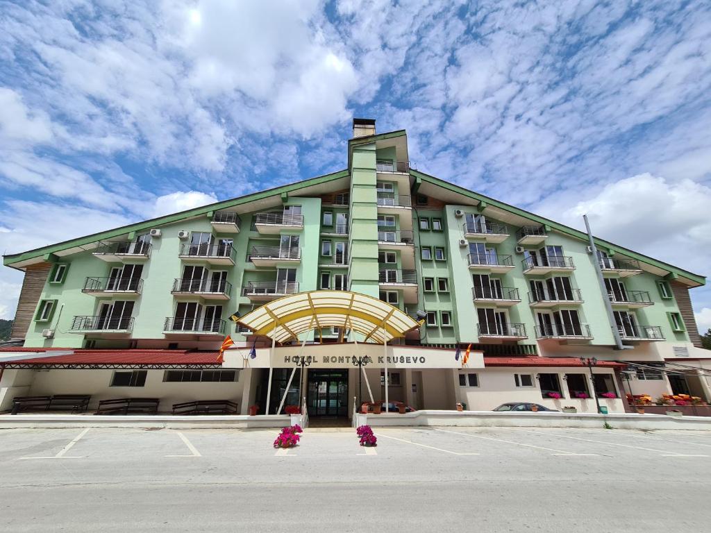 un grande edificio con fiori rosa di fronte di Hotel Montana Palace a Kruševo