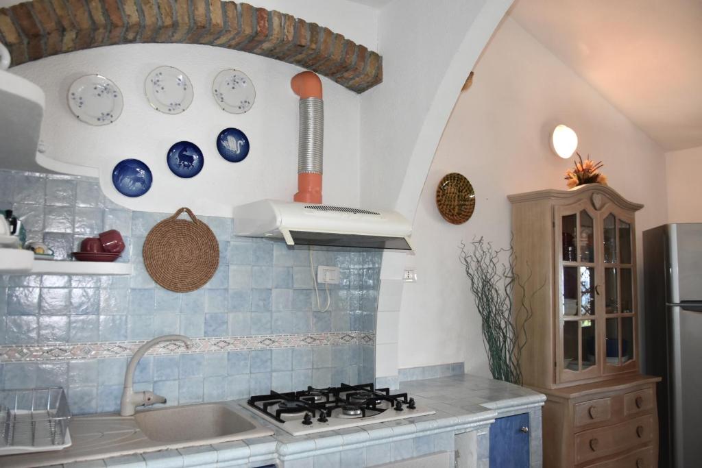uma cozinha com um lavatório e um fogão forno superior em Domus Deborah Apartment with sea view Costa rei em Costa Rei