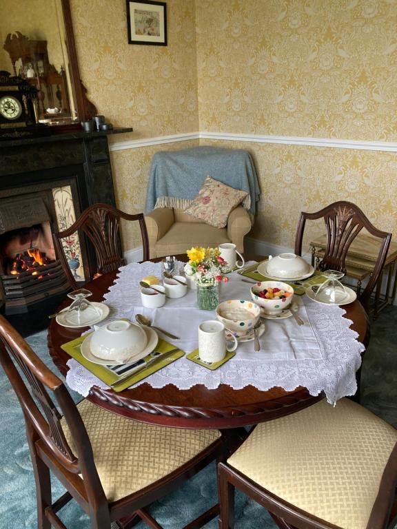 a table with a plate of food and a fireplace at Ballyginniff Farm House in Crumlin