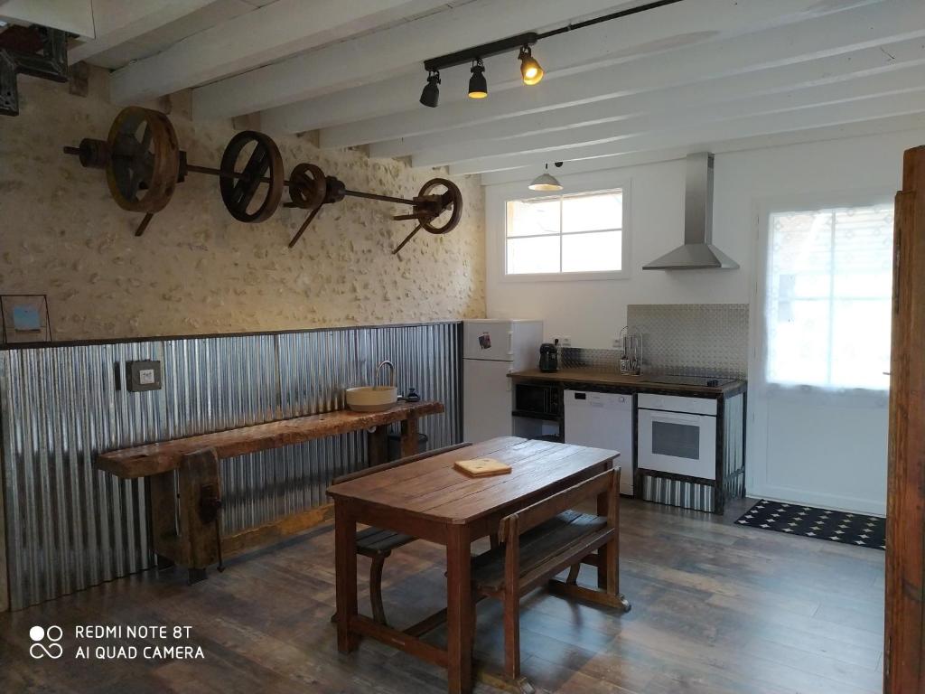 a kitchen with a wooden table in a room at Gîte L'atelier in Civray-de-Touraine