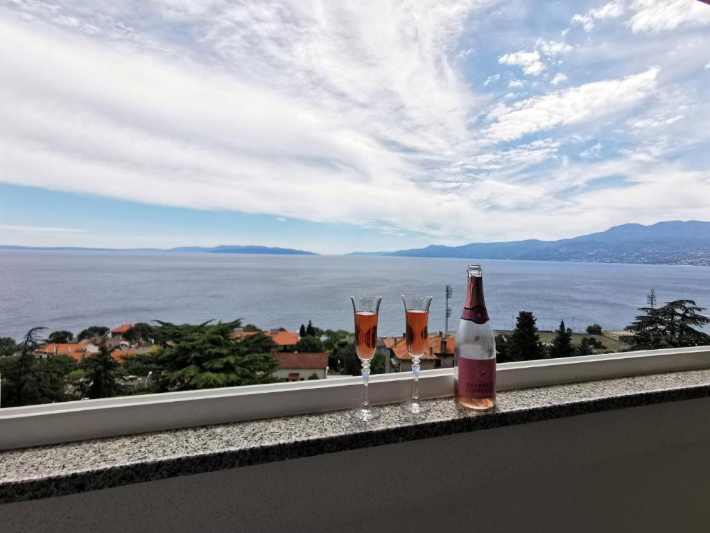 una botella de vino y tres copas de vino en una cornisa en Kvarner Sea View Apartment Rijeka, en Rijeka