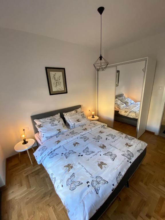 - une chambre avec un lit et un grand miroir dans l'établissement Harmony Suite, à Trebinje