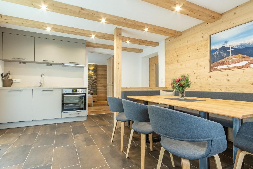 een keuken en eetkamer met een houten tafel en stoelen bij amHOPPEN in Wenns