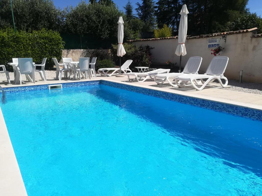 a large swimming pool with chairs and umbrellas at Apartments Sandra in Poreč