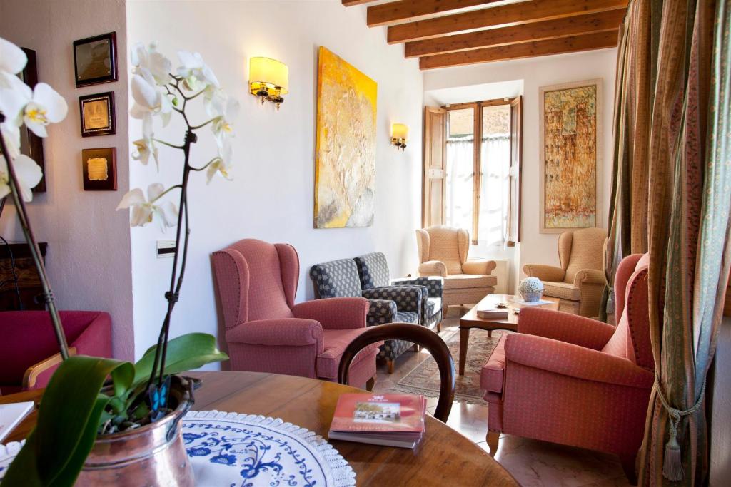 a living room with pink chairs and a table at Juma Historic Hotel in Pollença