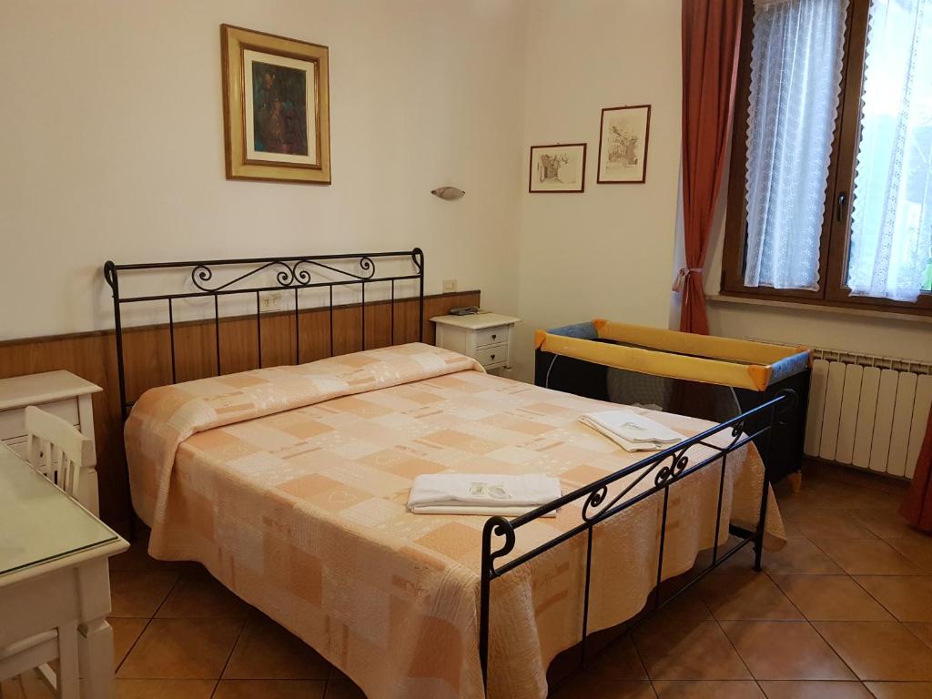 um quarto com uma cama, uma mesa e uma janela em Albergo Sonia em Florença