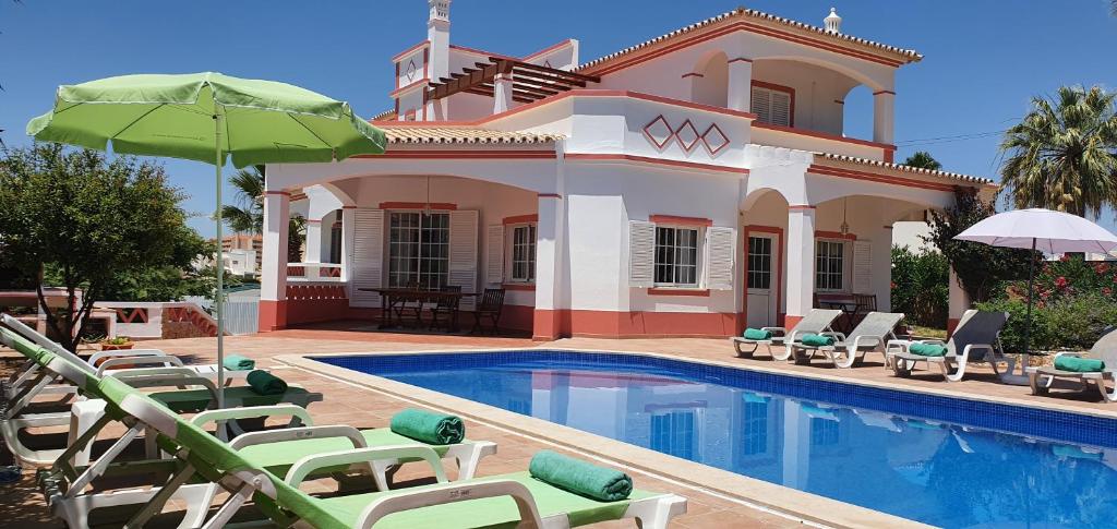 Villa con piscina con sillas y sombrilla en Villa Mar, en Albufeira