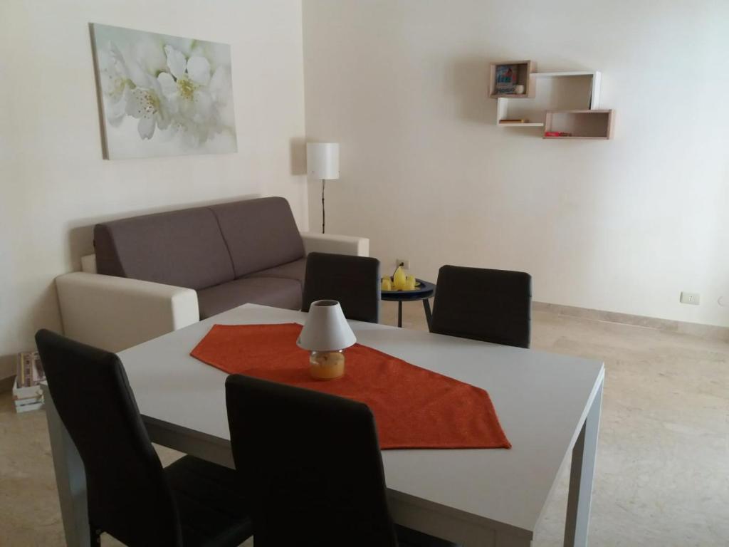 sala de estar con mesa y sofá en Appartamento vicino al mare en Giardini Naxos