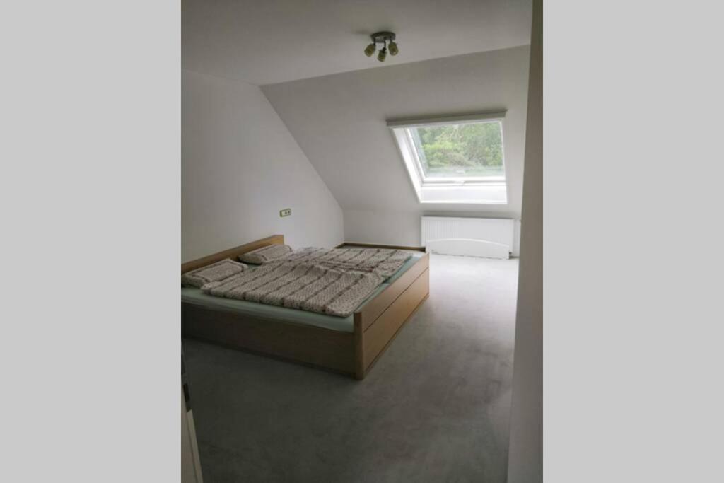 1 dormitorio con 1 cama en una habitación con ventana en Bohmte Zuhause mit Aussicht, en Bohmte