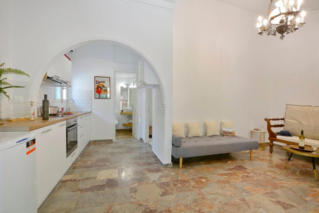 a kitchen and living room with a couch and an archway at Minimalist Cozy House in Corfu
