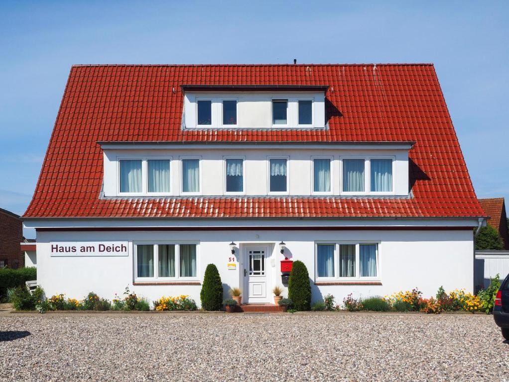 a white house with a red roof at Am Deich 51 in Dahme