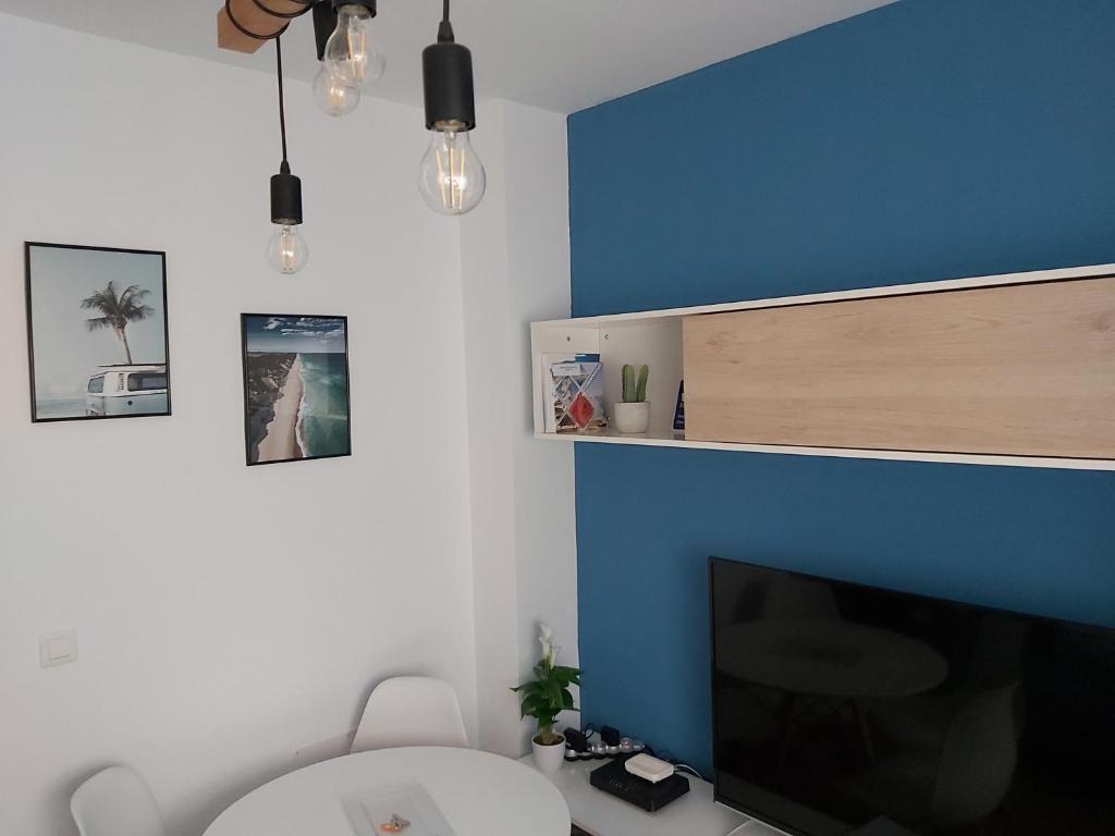 sala de estar con TV y pared azul en Apartamento Blue Garrucha, en Garrucha