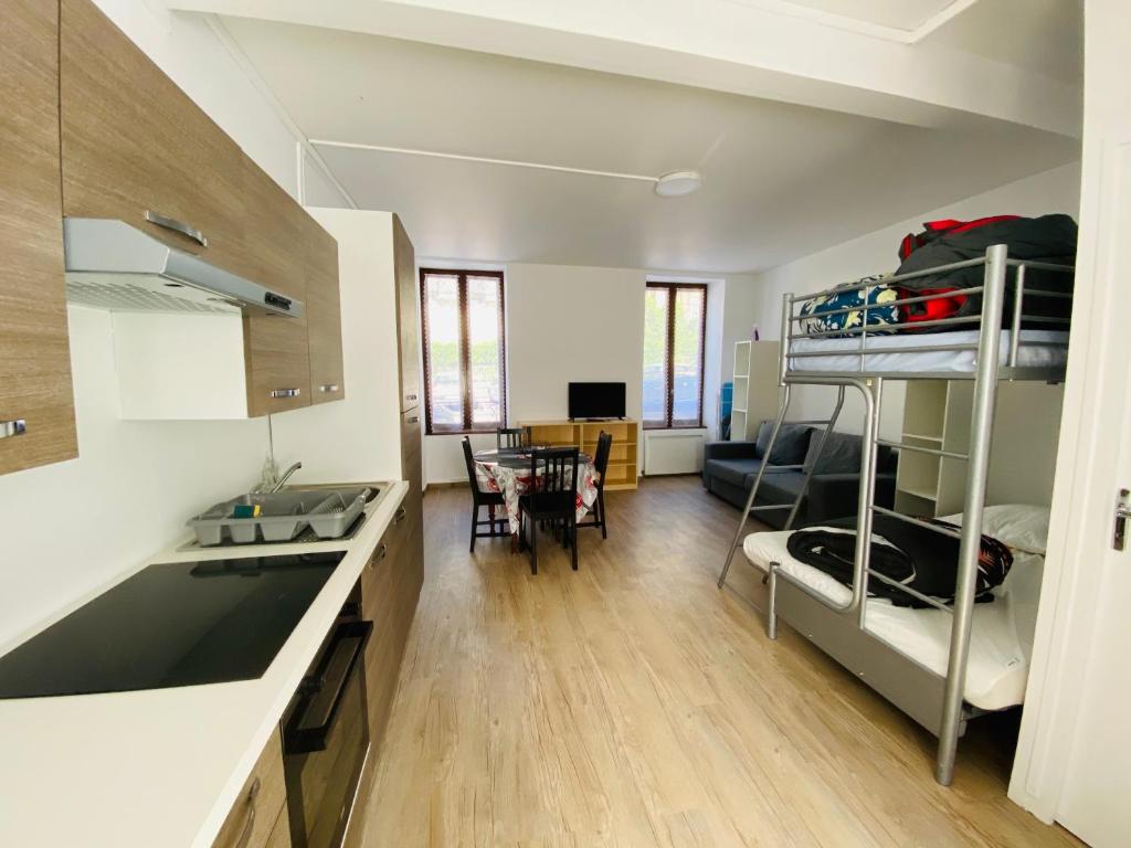 une cuisine et un salon avec un lit superposé dans l'établissement résidence les pâquerettes N 1, à Le Mont-Dore
