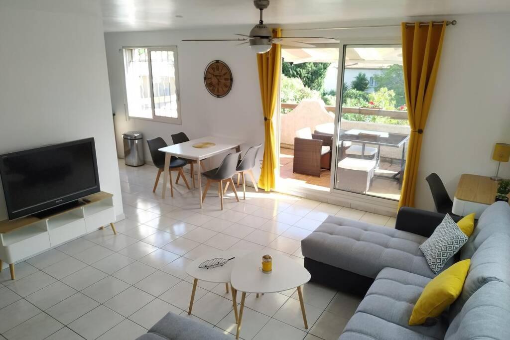 un salon avec un canapé bleu et une télévision dans l'établissement Appartement T3 Spacieux avec vue sur l'étang de Thau au 1er étage d'une villa - entrée indépendante, à Sète