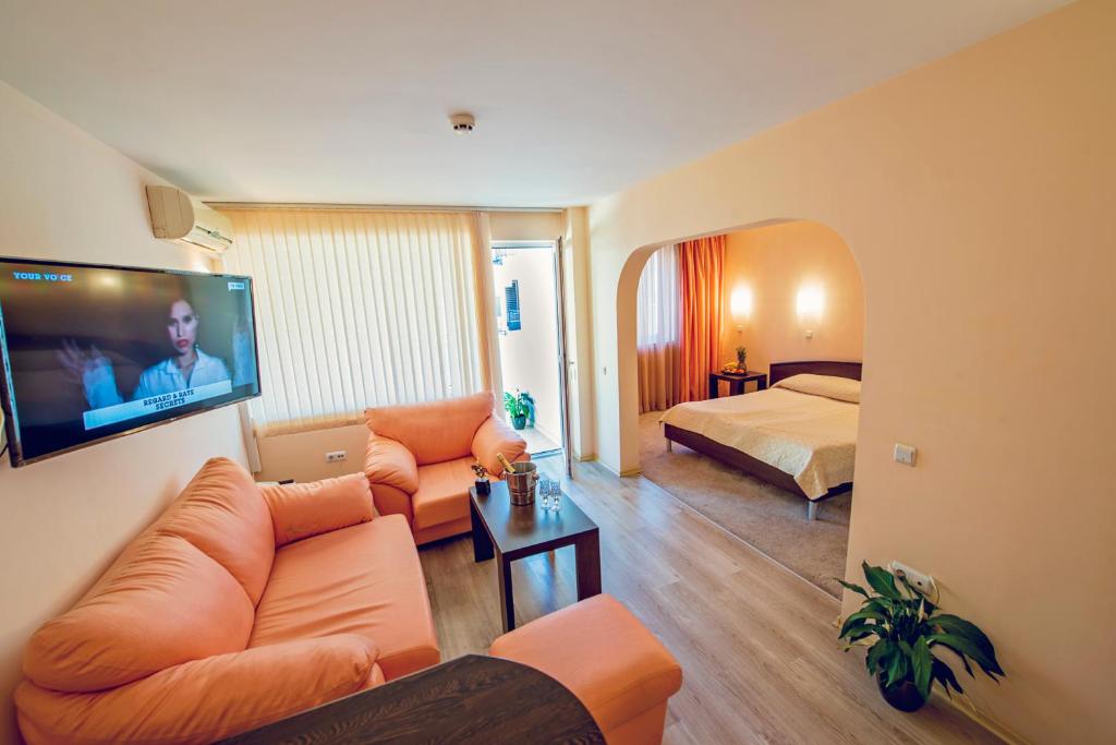 a living room with a couch and a bed and a television at Family Hotel Gran Ivan in Varna City