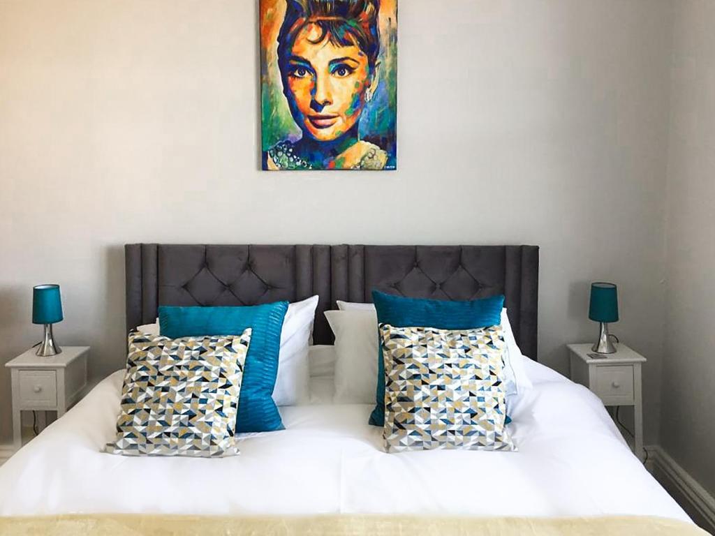 a bedroom with a bed with a painting on the wall at Upper Swan View Apartment in Harrogate