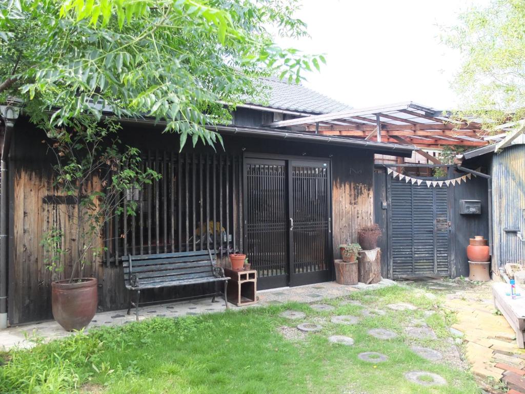 un jardín con un banco y una valla en YOMOGI GUESTHOUSE, en Tokoname