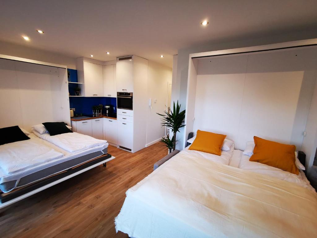 a bedroom with two beds with orange pillows at M&K Apartamenty Deluxe Gdańsk Sobieszewo 1 in Gdańsk