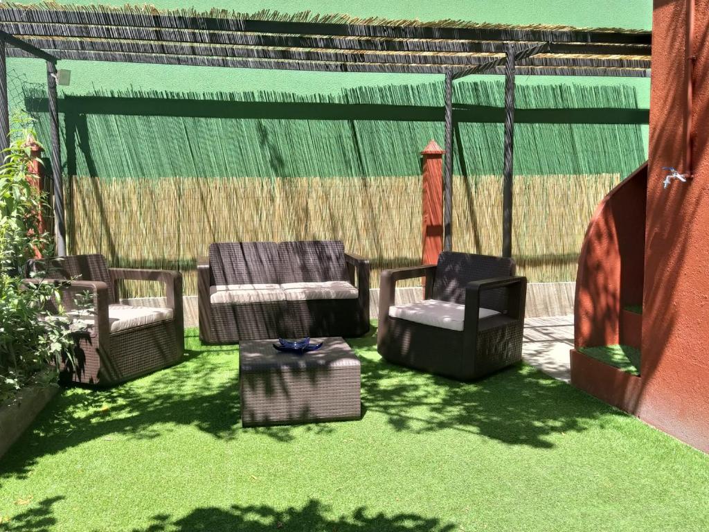a group of chairs sitting on a patio with grass at Casa Dana in Santiago de Compostela