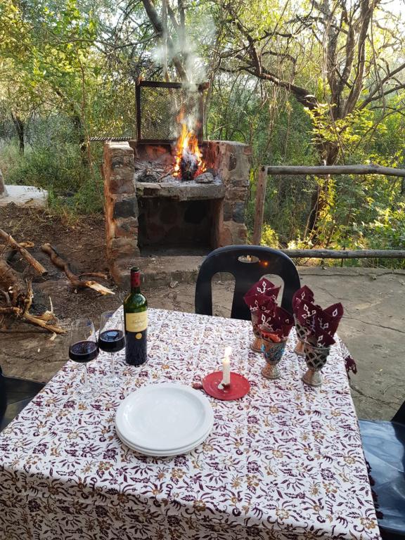umbabala bush camp في روستنبرج: طاولة مع صحن وفرن نار