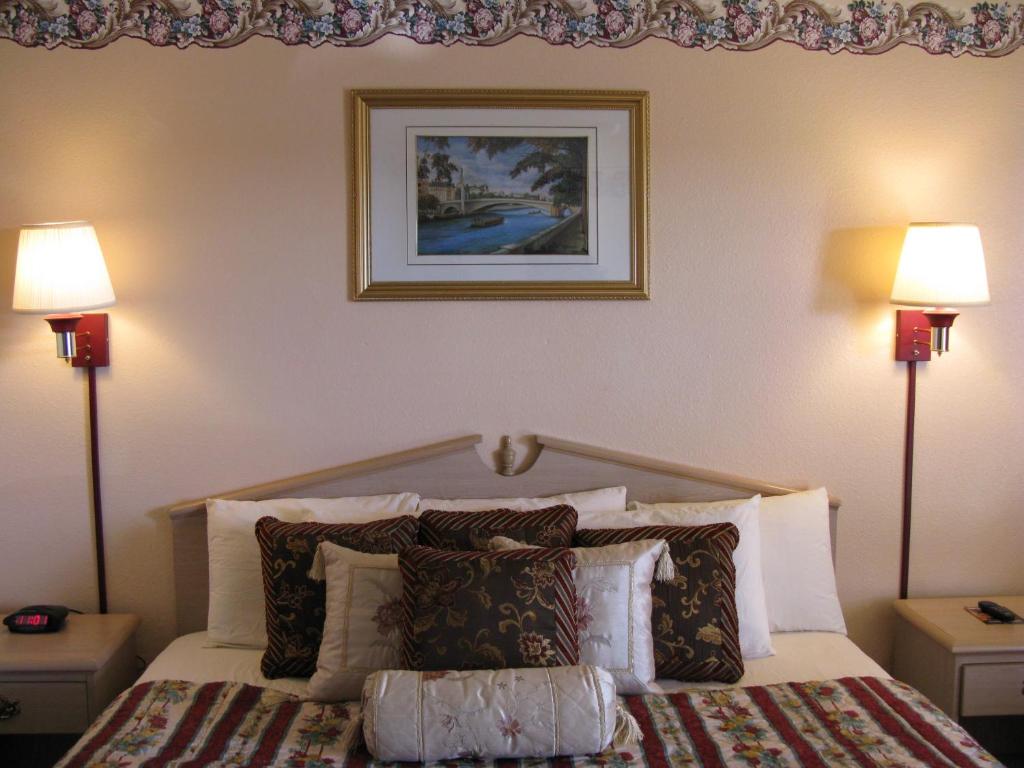 a bedroom with a bed with pillows and two lamps at Seminole Inn in Seminole