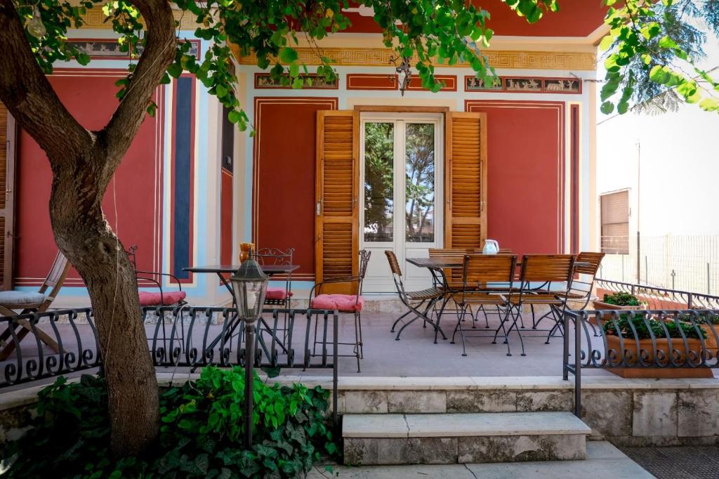 B&B De Angelis في جينوسا مارينا: فناء مع كراسي وطاولة على منزل
